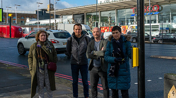 Lib dem activists standing by a pedestrian crossing on a busy road